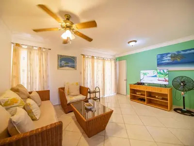 a living room with a couch and a flat screen tv at Garden Condos 40, 1br Apt In Sosua Strip Guest Ok in Sosúa