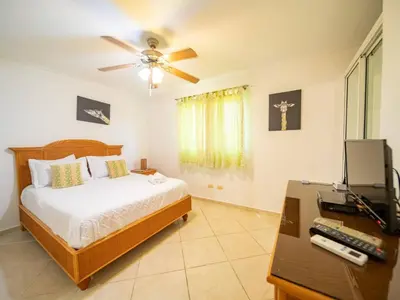 a bedroom with a bed and a desk with a television at Garden Condos 40, 1br Apt In Sosua Strip Guest Ok in Sosúa