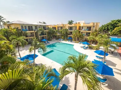 an aerial view of a resort swimming pool with palm trees at Garden Condos 40, 1br Apt In Sosua Strip Guest Ok in Sosúa