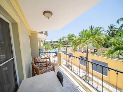 a balcony with a table and chairs and palm trees at Garden Condos 40, 1br Apt In Sosua Strip Guest Ok in Sosúa