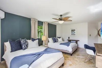 a bedroom with two beds and a ceiling fan at Private Two-Storey Casa de Campo villa with pool, jacuzzi and golf cart in La Romana