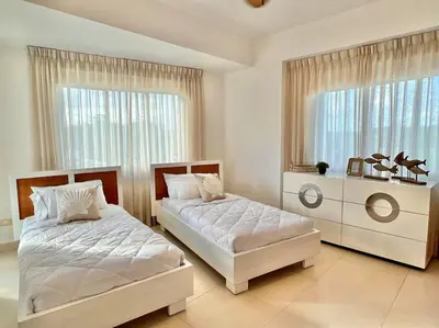 a bedroom with two beds and a window at Serenity by the Sea Oceanfront Apartment in San Pedro de Macorís