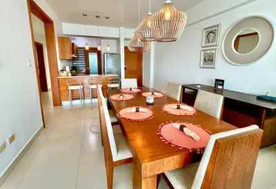 a dining room with a wooden table with chairs at Serenity by the Sea Oceanfront Apartment in San Pedro de Macorís