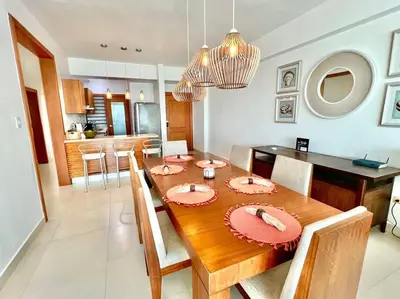 a dining room and kitchen with a table and chairs at Serenity by the Sea Oceanfront Apartment in San Pedro de Macorís