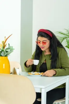 a woman sitting at a table with a cup of coffee at Hotel Dominican Barcelona in SJM