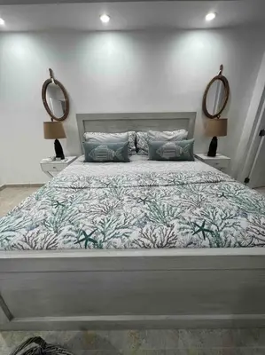 a bedroom with a large bed with two mirrors at Bueno Paradise Condo In Marbella in Juan Dolio