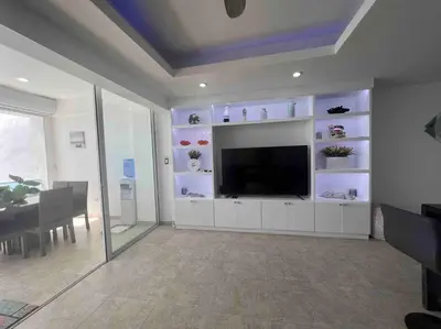 a living room with a large television and a table at Bueno Paradise Condo In Marbella in Juan Dolio