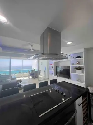 a kitchen with a black counter top and a view of the ocean at Bueno Paradise Condo In Marbella in Juan Dolio