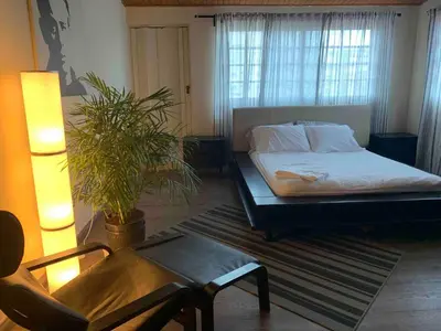 a bedroom with a bed and a chair and a plant at Modern Centrical Evaristo Apartment With Tub in Los Prados