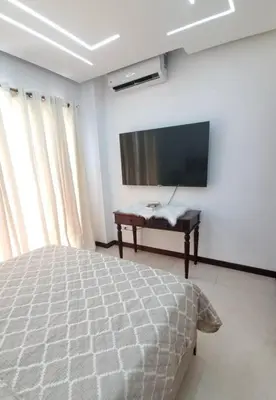 a bedroom with a bed and a flat screen tv at Hermoso apartamento con vista al mar y la ciudad in La Romana