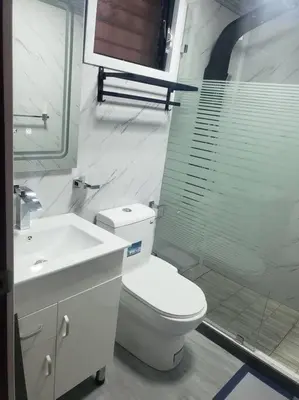 a white bathroom with a toilet and a sink at Desiderio in Santo Domingo