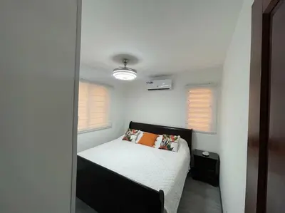 a bedroom with a bed and two windows at Desiderio in Santo Domingo