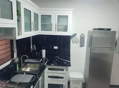 a kitchen with white cabinets and a stainless steel refrigerator at Desiderio in Santo Domingo