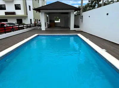 a large blue swimming pool in front of a building at Ático fantástico in Santiago de los Caballeros