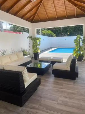 a living room with a couch and chairs and a pool at Ático fantástico in Santiago de los Caballeros