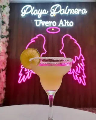 a drink sitting on a table with a neon sign at Hotel NEON in Punta Cana