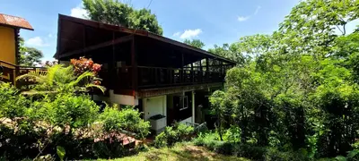 a building with a balcony in the middle of trees at Rancho Fernandez in Jarabacoa