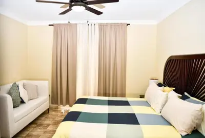 a bedroom with a bed and a couch at Punta Cana 1-Bed Apt Sleeps 4 with Pool & Hot Tub in Punta Cana
