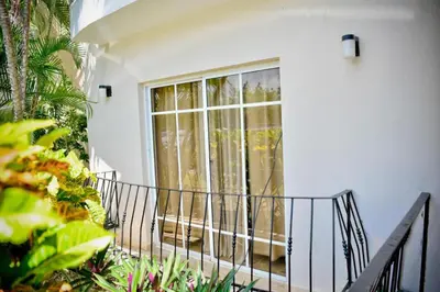 a balcony of a white house with a window at Punta Cana 1-Bed Apt Sleeps 4 with Pool & Hot Tub in Punta Cana