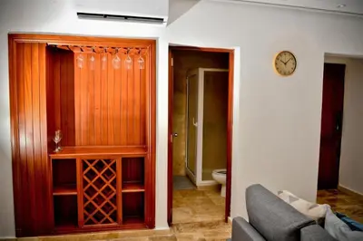 a living room with a couch and a clock on a wall at Punta Cana 1-Bed Apt Sleeps 4 with Pool & Hot Tub in Punta Cana
