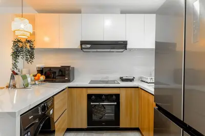 a kitchen with white cabinets and a black dishwasher at Beauty condo pool views with gym close to the beach in Punta Cana