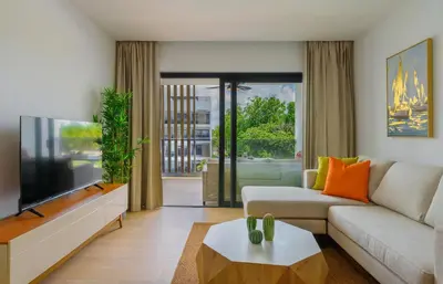 a living room with a couch and a tv at Beauty condo pool views with gym close to the beach in Punta Cana