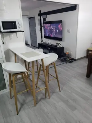 a table and two chairs in a room with a tv at Los Robles in Santo Domingo