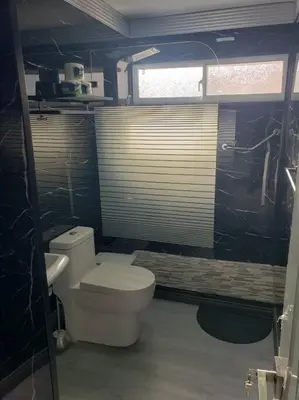 a bathroom with a white toilet and a sink at Los Robles in Santo Domingo