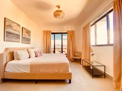 a bedroom with a bed and a large window at Condo hotel rialto Recidences in Santiago de los Caballeros