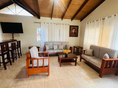 a living room with couches and chairs and a television at Encantadora Terraza de Brisas Frescas in Jarabacoa