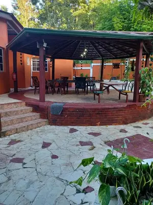 a pavilion with tables and benches and a table at villa mariposa in Santo Domingo