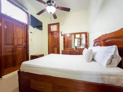 a bedroom with a bed with a ceiling fan at Charming Colonial Santo Domingo in Santo Domingo