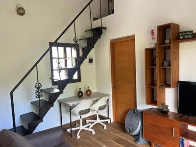 a living room with a desk and a spiral staircase at Villa Tierrita in Santa Bárbara de Samaná