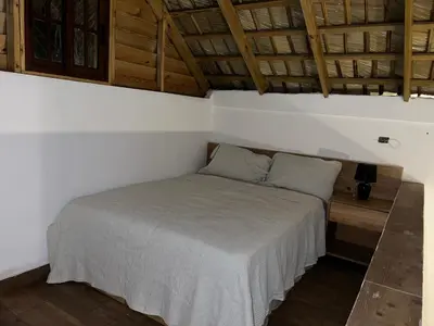a bedroom with a bed in a room with wooden ceilings at Villa Tierrita in Santa Bárbara de Samaná