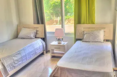 two beds in a room with a window at 2 Bedroom Pool Villa in Gated Encuentro Residences by Palm Hills Real Estate in Cabarete