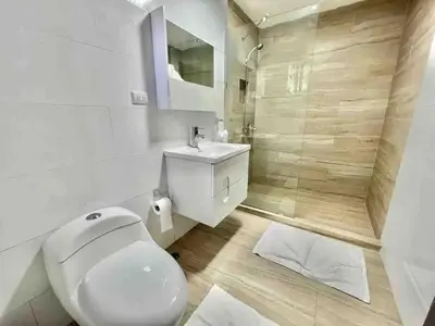 a white bathroom with a toilet and a shower at Exclusive Paradise Palms Villa in Sosúa