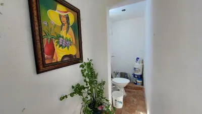 a bathroom with a painting on the wall and a toilet at Increible Casa Con Piscina! in Los Frailes