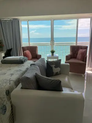 a living room with a couch and a view of the ocean at Hermoso Aparta- Estudio Frente al Mar in Santo Domingo