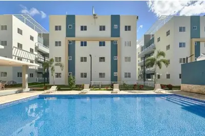 a swimming pool in front of a building at Disfruta, te lo mereces in La Romana