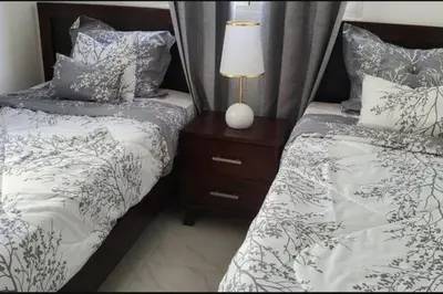 a bedroom with two beds and a lamp on a night stand at Disfruta, te lo mereces in La Romana