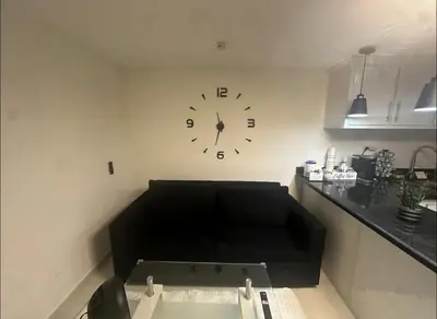 a living room with a clock on the wall at Luxury Apartment Hot Water,AC,WiFi,PS3 in San Felipe de Puerto Plata