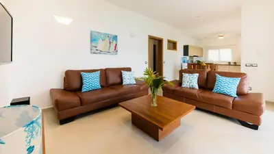 a living room with two brown couches and a coffee table at Aligio Apart-hotel & Spa - Las Terrenas in Las Terrenas