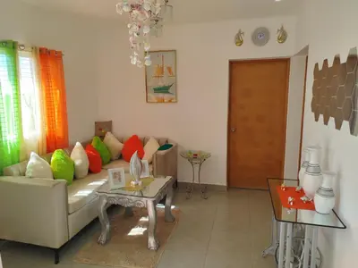 a living room with a couch with colorful pillows at Higüey City Home in Higuey
