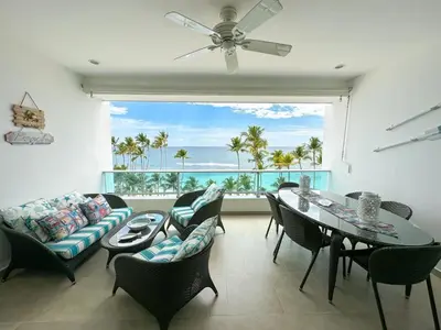 a living room with a table and chairs and a large window at Marbella, Juan Dolio, Republica Dominicana in Juan Pedro