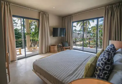 a bedroom with a large bed and a balcony at Coconut Beach House Playa Bonita Las terrenas Dominican Republic in Las Terrenas