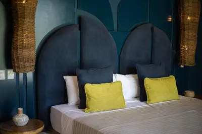 a blue bedroom with a bed with two yellow pillows at Coconut Beach House Playa Bonita Las terrenas Dominican Republic in Las Terrenas