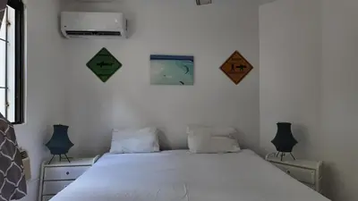 a bedroom with a white bed with two night stands at Aparta Hotel Monte Vista Sosua in Sosúa
