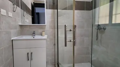 a bathroom with a sink and a glass shower at Aparta Hotel Monte Vista Sosua in Sosúa