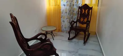 a room with two wooden chairs and a table at Villa Dario in Nagua