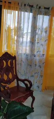 a wooden chair sitting in front of a window at Villa Dario in Nagua
